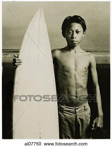 Indonesia, Bali, Kuta Beach, Young surfer holding surfboard on the beach. View Large Photo Image Stock Image - Indonesia, Bali, Kuta Beach, Young surfer holding surfboard on the beach.. Fotosearch