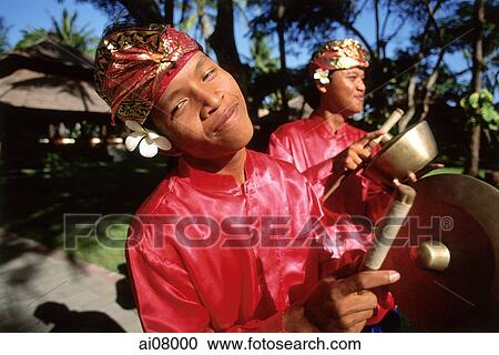 Indonesia, Bali, Kuta, Smiling gamelan players in hotel grounds. (grainy) View Large Photo Image Stock Image - Indonesia, Bali, Kuta, Smiling gamelan players in hotel grounds. (grainy). Fotosearch