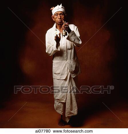 Indonesia, Bali, Ubud, Hindu priest holding prayer bell and flower. View Large Photo Image Stock Image - Indonesia, Bali, Ubud, Hindu priest holding prayer bell and flower.. Fotosearch