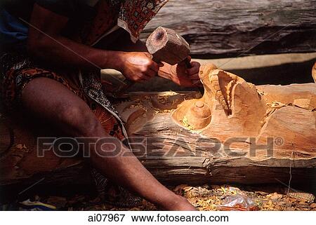 Indonesia, Bali, Ubud, Woodcarver carving from tree trunk. (grainy) View Large Photo Image Stock Photo - Indonesia, Bali, Ubud, Woodcarver carving from tree trunk. (grainy). Fotosearch