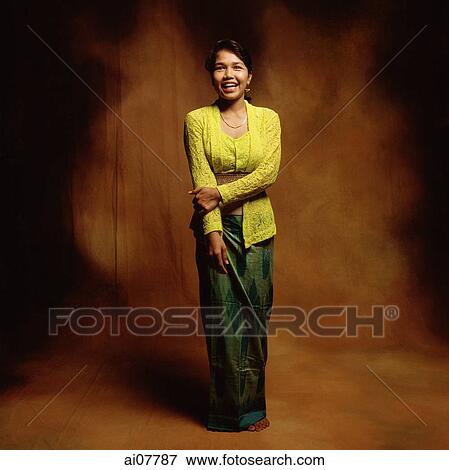 Stock Photo - Indonesia, Bali, Ubud, Young Balinese woman in temple dress smiling.. Fotosearch
