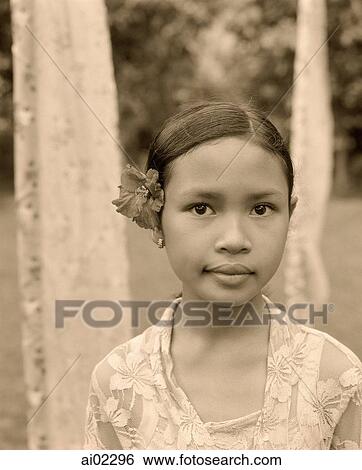 Indonesia, Bali, young girl with flower behind ear, portrait View Large Photo Image Stock Photograph - Indonesia, Bali, young girl with flower behind ear, portrait. Fotosearch