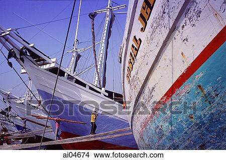 Indonesia, Jakarta, Sunder kelapa, men unloading goods from boats. View Large Photo Image Picture - Indonesia, Jakarta, Sunder kelapa, men unloading goods from boats.. Fotosearch
