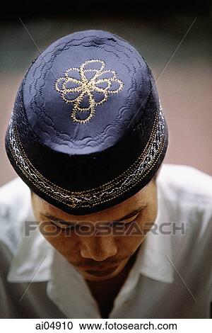 Indonesia, Jakarta, Worshipper wears an embroidered prayer cap, called a songkok or kopiah, at Istiqlal Mosque. View Large Photo Image Stock Image - Indonesia, Jakarta, Worshipper wears an embroidered prayer cap, called a songkok or kopiah, at Istiqlal Mosque.. Fotosearch