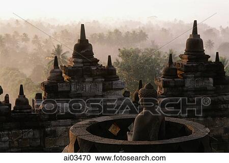 Indonesia, Java, Buddha figure at Borobudur temple, trees in background View Large Photo Image Stock Image - Indonesia, Java, Buddha figure at Borobudur temple, trees in background. Fotosearch