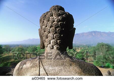 Stock Photography - Indonesia, Java, Buddha figure at Borobudur temple, mountains in background. Fotosearch
