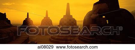 Indonesia, Java, Magelang, Sunrise across stupas on top level of Candi Borobudur. (grainy) View Large Photo Image Stock Photo - Indonesia, Java, Magelang, Sunrise across stupas on top level of Candi Borobudur. (grainy). Fotosearch