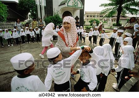 Indonesia, Riau Islands, Tanjung Pinang, Muslim teacher playing with students. View Large Photo Image Stock Image - Indonesia, Riau Islands, Tanjung Pinang, Muslim teacher playing with students.. Fotosearch