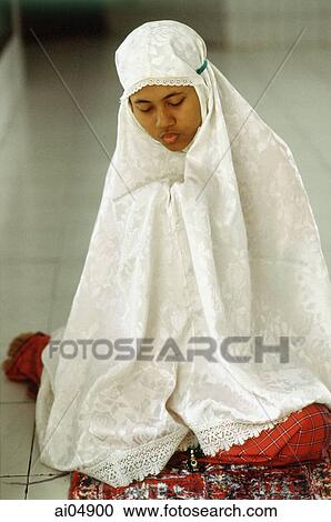 Indonesia, student clutches her Koran beneath a prayer shawl. View Large Photo Image Stock Image - Indonesia, student clutches her Koran beneath a prayer shawl.. Fotosearch