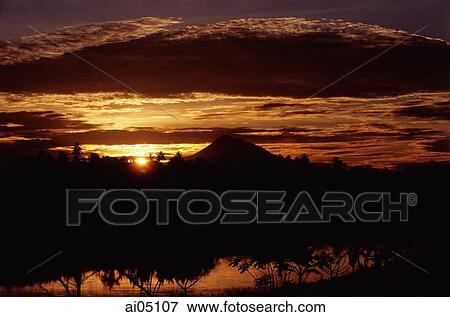 Indonesia, Sumatra, Aceh, The sun setting over the mountains. View Large Photo Image Stock Photo - Indonesia, Sumatra, Aceh, The sun setting over the mountains.. Fotosearch