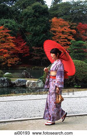 Japan, woman in kimono walking in temple garden with red umbrella View Large Photo Image Stock Image - Japan, woman in kimono walking in temple garden with red umbrella. Fotosearch