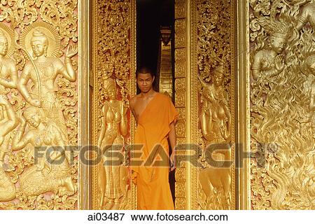 Laos, Luang Prabang, A young monk stands in the doorway of a temple View Large Photo Image Stock Photo - Laos, Luang Prabang, A young monk stands in the doorway of a temple. Fotosearch