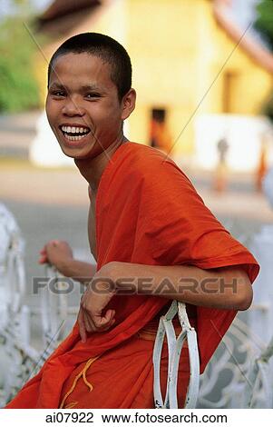 Laos, Luang Prabang, Novice monk in front of Wat Xieng Thong Temple. (grainy) View Large Photo Image Stock Image - Laos, Luang Prabang, Novice monk in front of Wat Xieng Thong Temple. (grainy). Fotosearch
