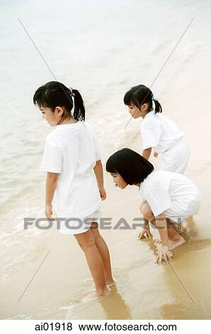 Little girls on beach looking at waves View Large Photo Image Stock Photo - Little girls on beach looking at waves. Fotosearch