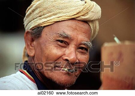 Malaysia, Kota Bahru, A Malay Muslim fisherman smokes a hand-rolled cigarette. View Large Photo Image Stock Image - Malaysia, Kota Bahru, A Malay Muslim fisherman smokes a hand-rolled cigarette.. Fotosearch