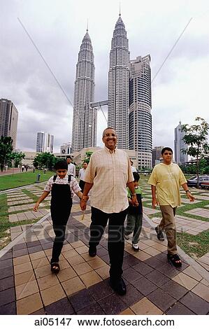 Malaysia, Kuala Lumpur, Malay family walking, Petronas Twin Towers in background. View Large Photo Image Stock Photo - Malaysia, Kuala Lumpur, Malay family walking, Petronas Twin Towers in background.. Fotosearch