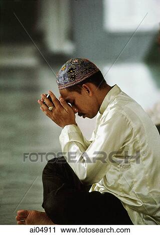 Malaysia, Kuala Lumpur, Malay man holds a small Koran and prays. View Large Photo Image Stock Image - Malaysia, Kuala Lumpur, Malay man holds a small Koran and prays.. Fotosearch