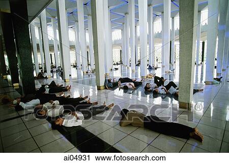 Stock Image - Malaysia, Kuala Lumpur, men resting after Friday Prayers in the National Mosque.. Fotosearch