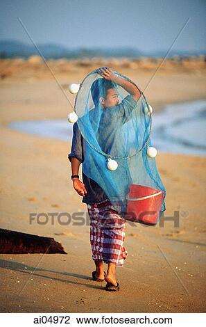 Malaysia, Marang River, fisherman walks along the beach carrying net and bucket. View Large Photo Image Stock Image - Malaysia, Marang River, fisherman walks along the beach carrying net and bucket.. Fotosearch