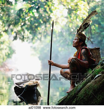 Malaysia, Sarawak, Sri Aman Division, Engkilili, Iban Shaman wearing traditional dress at riverside View Large Photo Image Stock Photo - Malaysia, Sarawak, Sri Aman Division, Engkilili, Iban Shaman wearing traditional dress at riverside. Fotosearch