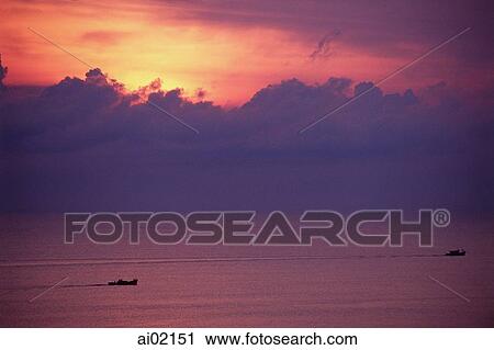 Stock Image - Malaysia, South China Sea, sunrise behind fishermen off of east coast.. Fotosearch