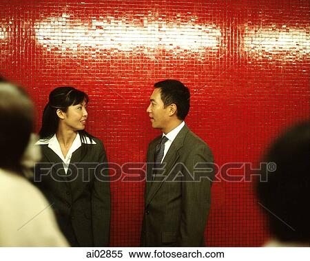 Male and female executives leaning against red wall talking. View Large Photo Image Stock Photography - Male and female executives leaning against red wall talking.. Fotosearch