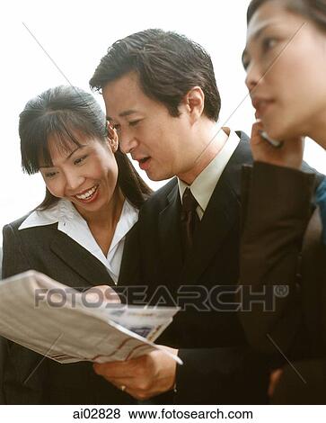 Male and female executives sharing newspaper. View Large Photo Image Stock Photo - Male and female executives sharing newspaper.. Fotosearch