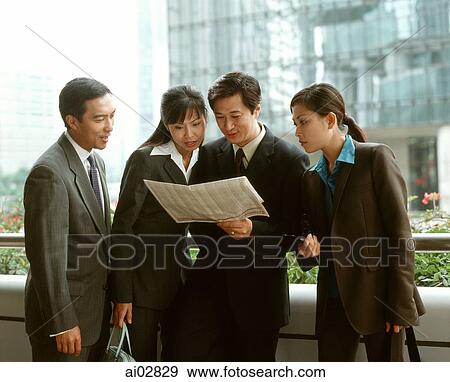Male and female executives sharing newspaper, buildings in background. View Large Photo Image Stock Photo - Male and female executives sharing newspaper, buildings in background.. Fotosearch