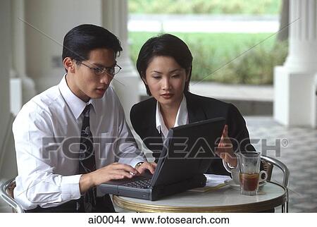 Male and female executives working on laptop computer in cafe View Large Photo Image Picture - Male and female executives working on laptop computer in cafe. Fotosearch