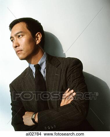 Picture - Male executive against white background, looking off camera.. Fotosearch