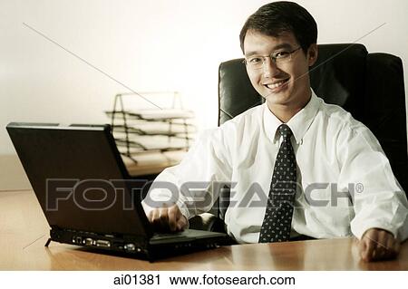 Male executive at desk with laptop. View Large Photo Image Stock Image - Male executive at desk with laptop.. Fotosearch