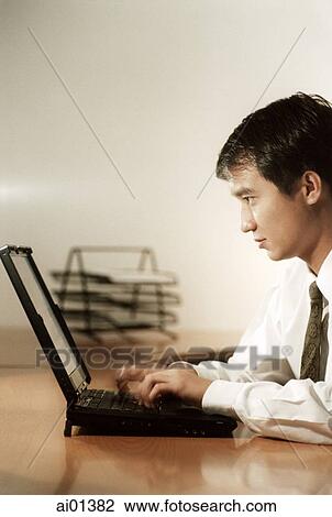Male executive at desk with laptop, profile. View Large Photo Image Stock Image - Male executive at desk with laptop, profile.. Fotosearch
