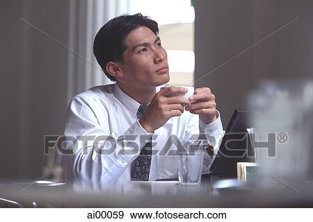 Male executive holding coffee cup in cafe, thoughtful expression View Large Photo Image Stock Photo - Male executive holding coffee cup in cafe, thoughtful expression. Fotosearch