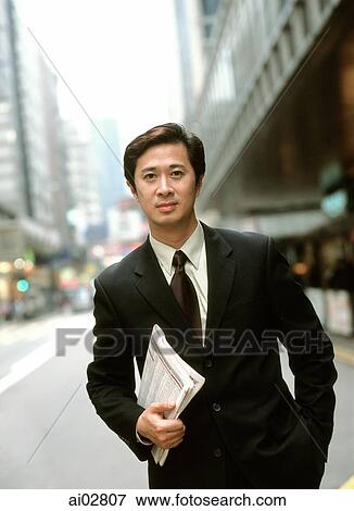 Male executive holding newspaper on street, portrait. View Large Photo Image Stock Photo - Male executive holding newspaper on street, portrait.. Fotosearch
