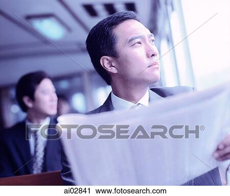 Male executive holding newspaper looking off camera. View Large Photo Image Stock Image - Male executive holding newspaper looking off camera.. Fotosearch