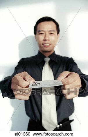Male executive holding out business card. View Large Photo Image Stock Image - Male executive holding out business card.. Fotosearch