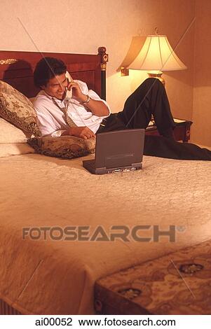 Male executive in hotel room talking on phone, with laptop computer View Large Photo Image Stock Image - Male executive in hotel room talking on phone, with laptop computer. Fotosearch