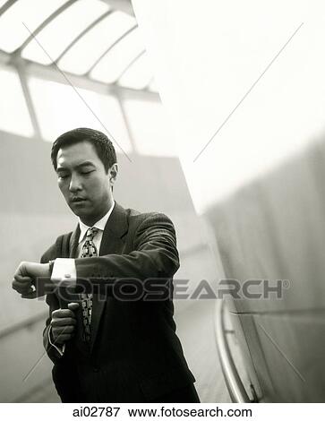 Male executive looking at watch. View Large Photo Image Stock Photo - Male executive looking at watch.. Fotosearch