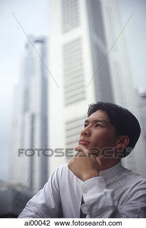 Stock Image - Male executive looking up, thoughtful expression. Fotosearch