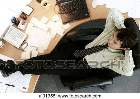 Male executive relaxing at desk, top view. View Large Photo Image Stock Photography - Male executive relaxing at desk, top view.. Fotosearch