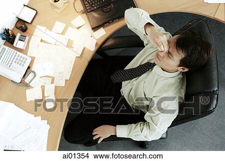 Male executive sitting at desk, top view. View Large Photo Image Picture - Male executive sitting at desk, top view.. Fotosearch