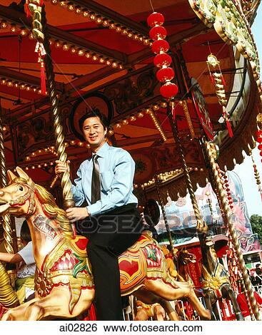 Male executive sitting on carousel. View Large Photo Image Stock Photograph - Male executive sitting on carousel.. Fotosearch