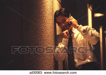 Male executive talking on cellular phone under street lamp at night View Large Photo Image Stock Image - Male executive talking on cellular phone under street lamp at night. Fotosearch