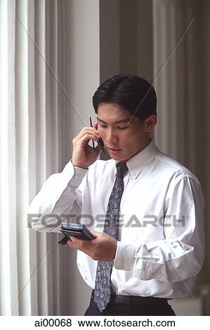 Male executive talking on cellular phone, pillars behind View Large Photo Image Stock Photo - Male executive talking on cellular phone, pillars behind. Fotosearch