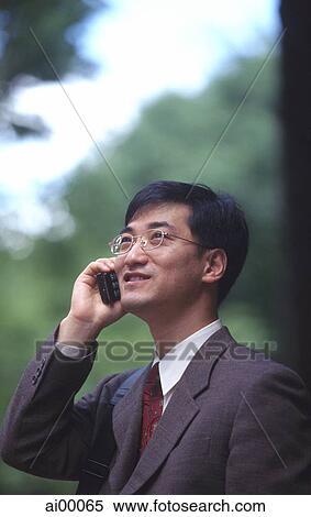 Male executive talking on cellular phone, trees behind View Large Photo Image Stock Photography - Male executive talking on cellular phone, trees behind. Fotosearch