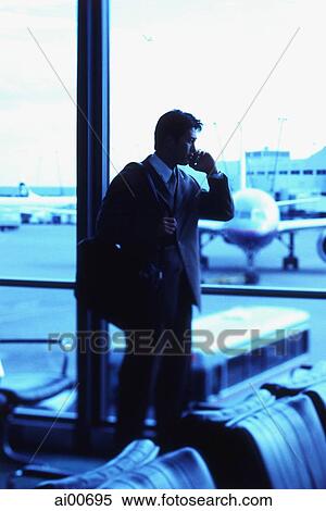 Male executive talking on cellular phone in airport lounge View Large Photo Image Stock Photography - Male executive talking on cellular phone in airport lounge. Fotosearch