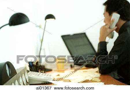 Male executive talking on phone with laptop behind, rearview. View Large Photo Image Stock Photo - Male executive talking on phone with laptop behind, rearview.. Fotosearch