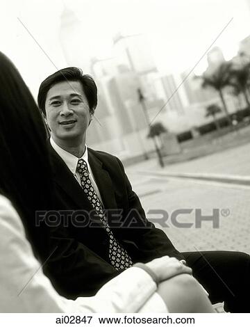 Male executive talking to female outdoors, skyline in background. View Large Photo Image Stock Photo - Male executive talking to female outdoors, skyline in background.. Fotosearch