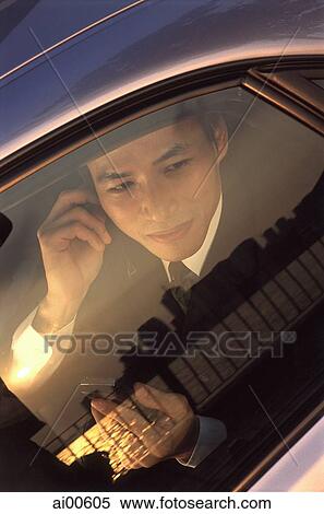 Male executive using cellular phone, sunset reflected in car window View Large Photo Image Stock Photography - Male executive using cellular phone, sunset reflected in car window. Fotosearch