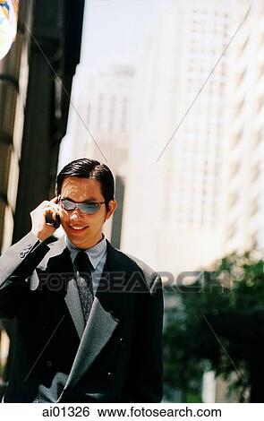 Male executive with sunglasses, using cellular phone View Large Photo Image Stock Photograph - Male executive with sunglasses, using cellular phone. Fotosearch